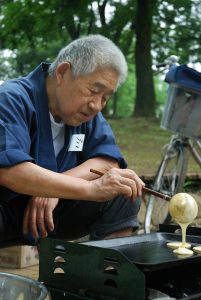 alter Japaner backt Pfannkuchen